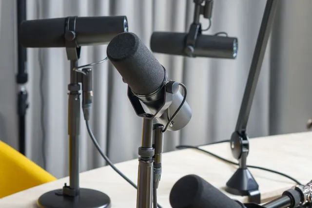 A sound wave becoming a speech bubble beside a stopwatch and a simple microphone